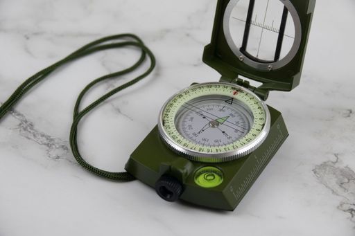 A navigation compass on a marbled surface, closeup shot