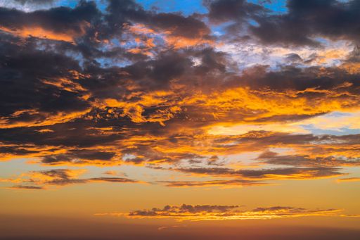 Sunset in August with vibrant colors and clouds.