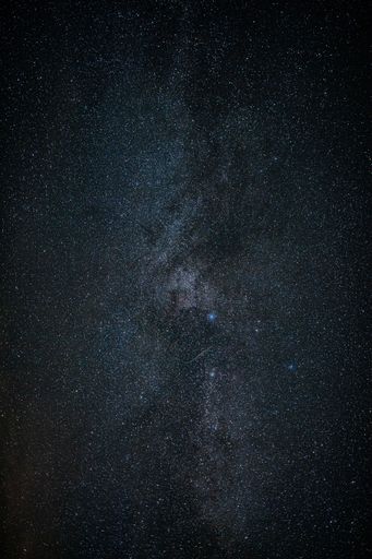 A long exposure shot of the mesmerizing starry night sky, in a vertical shot - great for a background