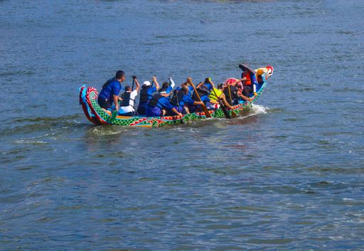 A group of people on beautiful boats during Asian traditional competition- the dragon race