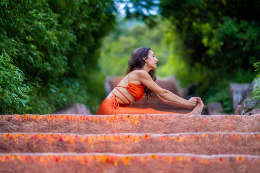 A scenic view of a Caucasian woman doing yoga poses inside an Indian temple