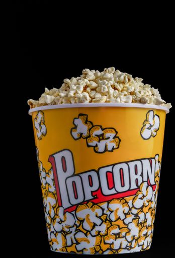 close-up of a popcorn container with colored letters on a black background