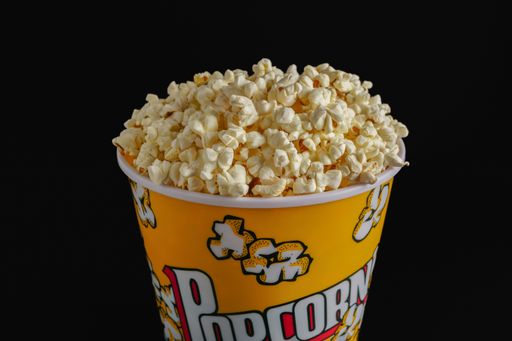 close-up of a popcorn container with colored letters on a black background