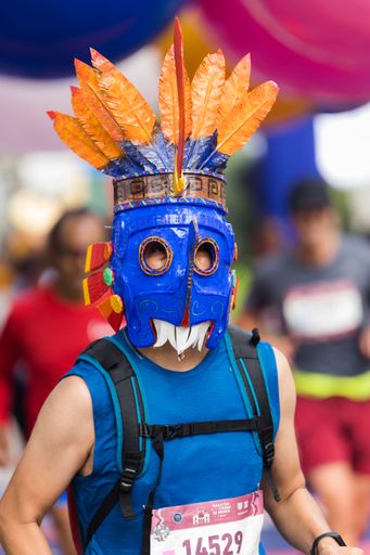 A masked man running the International Marathon of Mexico city on the street