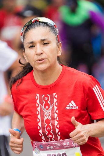 A woman running the International Marathon of Mexico city on the street