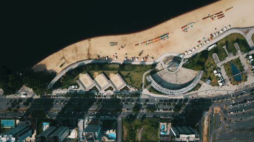 An aerial top view of modern buildings and a highway on a beach against a sea