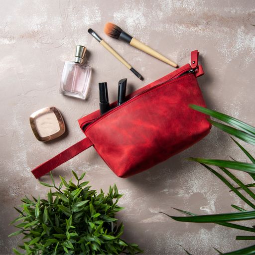 A top view of handmade leather makeup bag with brushes next to it