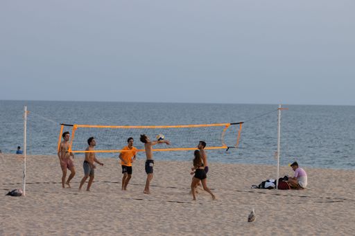 young people enjoying a day at the beach and playing volleyball