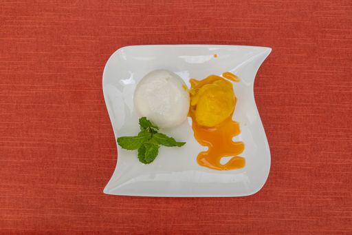 A top view of a egg white foam and yolk on a white square plate