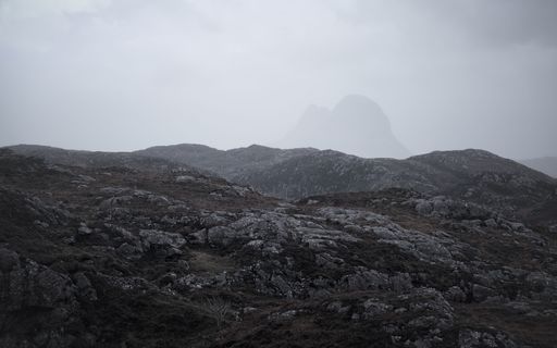 The peak of Suilven over grey gneiss rock