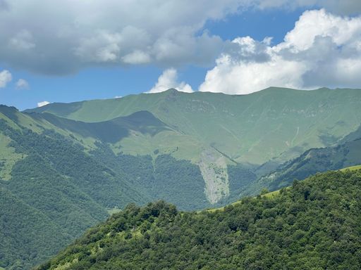 An aerial drone view of beautiful green mountains against a cloudy sky in Georgia