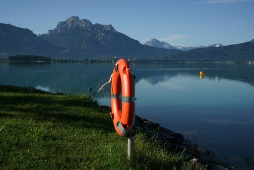 A ring buoy on the side of the lake surrounded by high mountains