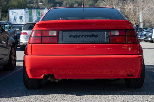 A closeup of a detail of a red Volkswagen Corrado parked on the street. The rear view