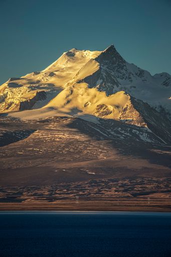 A vertical shot of the Pekucuo lake and Shishapangma snowy mountains during sunrise in Xigaze, China