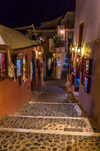 A vertical shot of an alley with stairs at the Santorini island din Greece during the nighttime