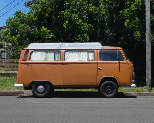 side view of brown vintage van parked outdoors on street with tree backround