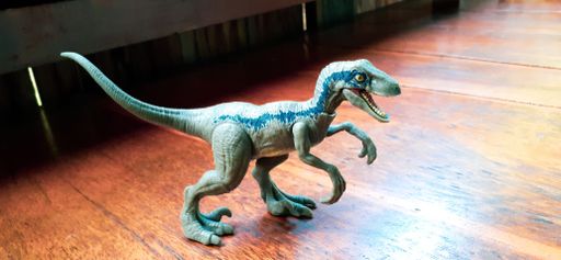 Velociraptor dinosaur toy on wooden table