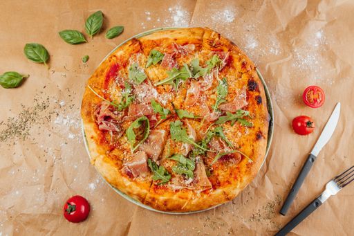 A flat lay of delicious pizza with fork and knife