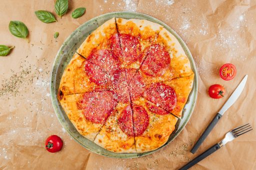 A flat lay of delicious pizza with fork and knife