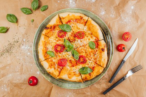A flat lay of delicious pizza with fork and knife