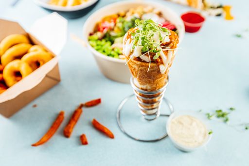 A high angle shot of a white table full of tasty looking dishes and snacks