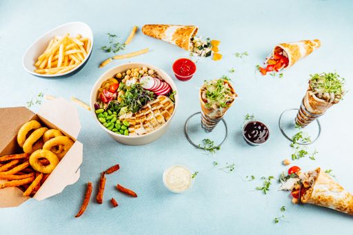 A flat lay of pizza cones and snack boxes