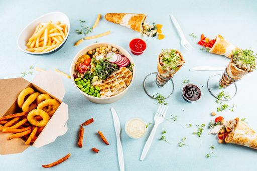 A high angle shot of a white table full of tasty looking dishes and snacks