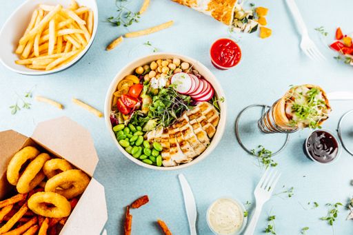 A high angle shot of a white table full of tasty looking dishes and snacks