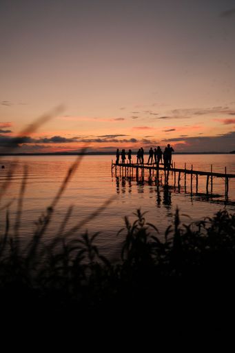 A vertical shot of silhouetted people standing on a pier in Madison, Wisconsin