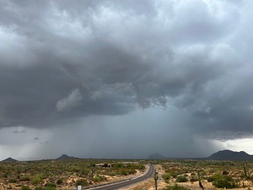 Dark clouds gathered over the road passing through the rural lands in North Scottsdale