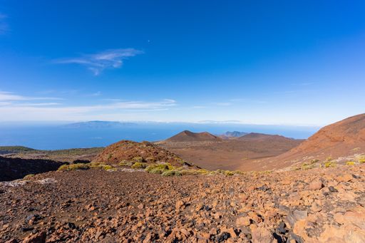 A volcanic landscape at the volcano Teide with a view towards the Atlantic Ocean and the neighboring islands of La Gomera and La Palma