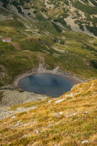 A vertical shot of a glacial lake located in the Fagaras Mountains, Romania.