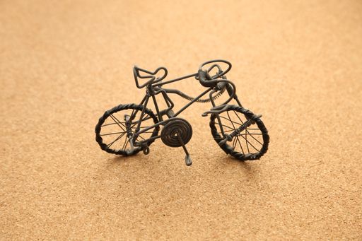 A high angle shot of a small bicycle figure on a beige background