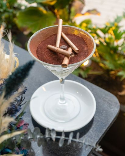 A vertical shot of a tiramisu dessert in a martini glass