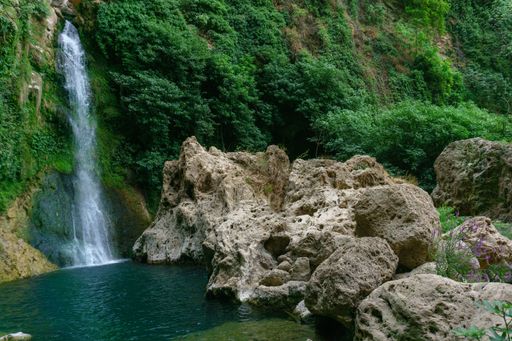 large waterfall over a natural pool for bathing with cold and crystalline water, silk effect, long exposure.
