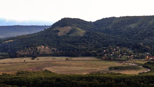 A beautiful scenery of a green mountainous landscape under a bright sky