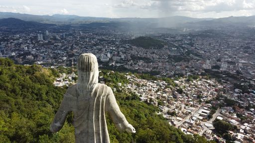 A drone shot of the Christ of the Peak statue over the cityscape in Tegucigalpa, Honduras