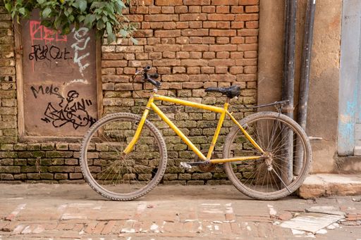 A beautiful shot of an old bicycle leaning against the wall in the street