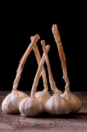 A vertical shot of garlic cloves on a wooden table