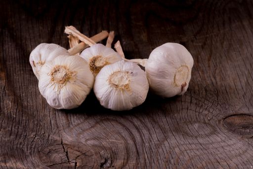 A closeup shot of garlic cloves on a wooden table