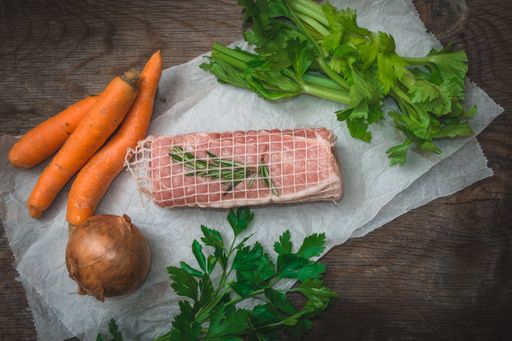 A closeup shot of a raw meat fillet with vegetables
