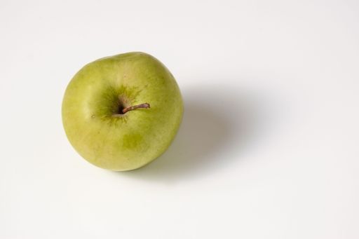 A top view of a green apple against a white background