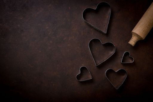 A top view of a wooden pin and heart-shaped metals used for baking