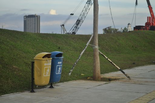 A street with blue and yellow trash bins for further processing of waste