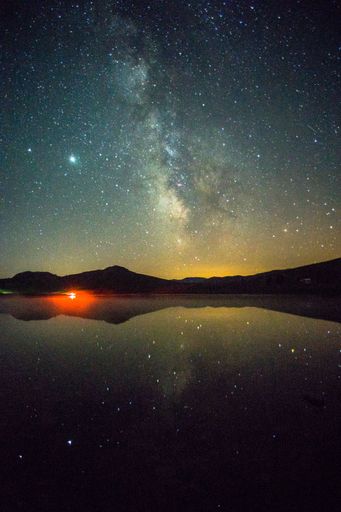 Milky way reflection in the lake with the red light on its ban