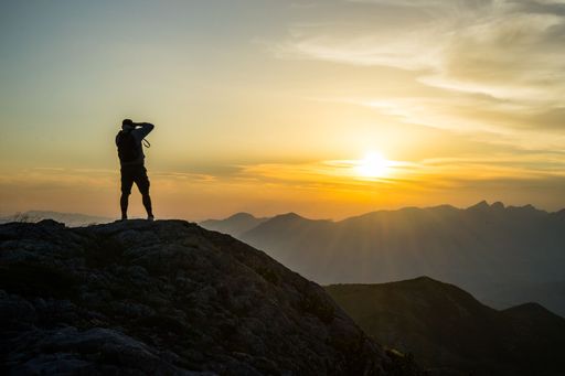 A silhouette of a photographer taking a photo of the sunset