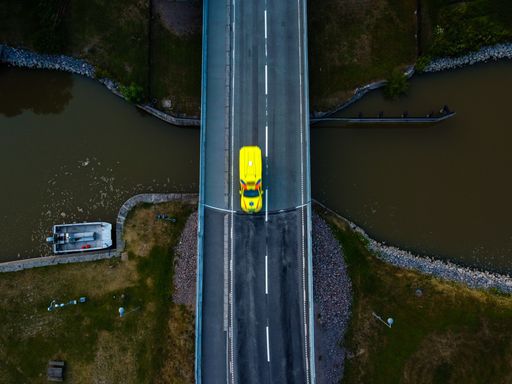 An aerial view of yellow bus on the country road