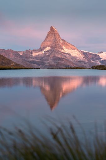Reflection of the Matterhorn mountain in the Stellisee lake at sunrise in Zermatt Switzerland with a peaceful and colourful atmosphere