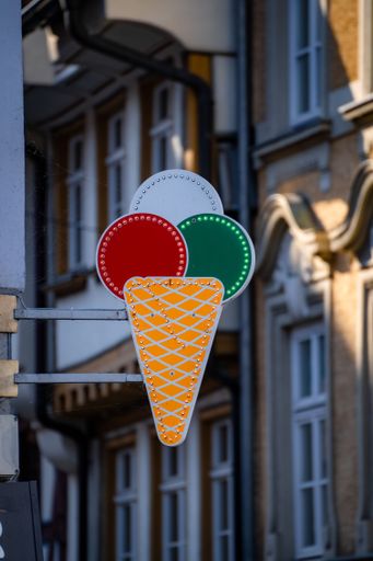 A vertical shot of an ice cream cone sign on the wall of an ice cream shop
