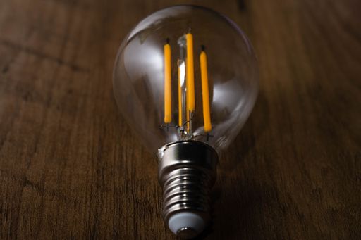 A closeup of a clear light bulb on a wooden surface